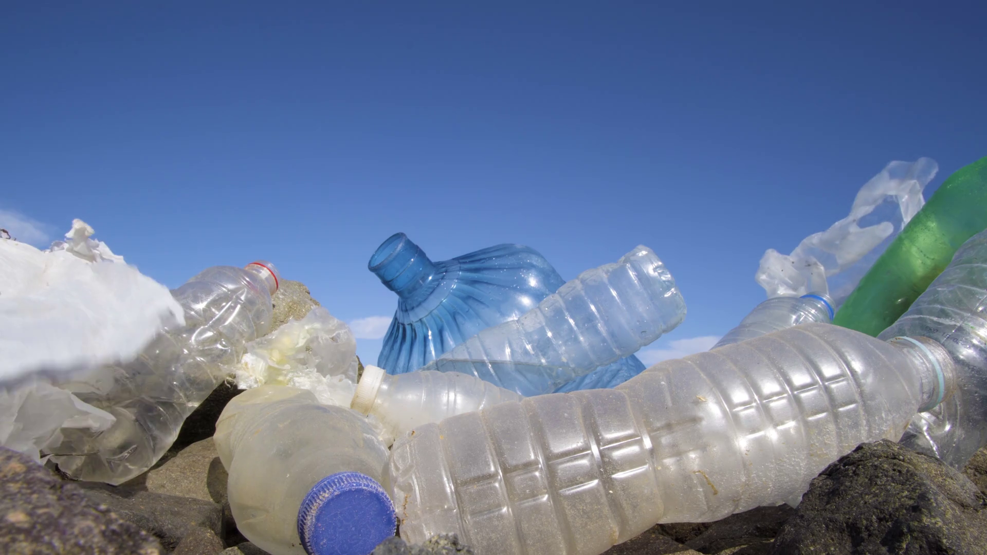 videoblocks-dirty-plastic-bottles-on-the-stone-beach-environmental-pollution_rdsvu0wxe_thumbnail-1080_01